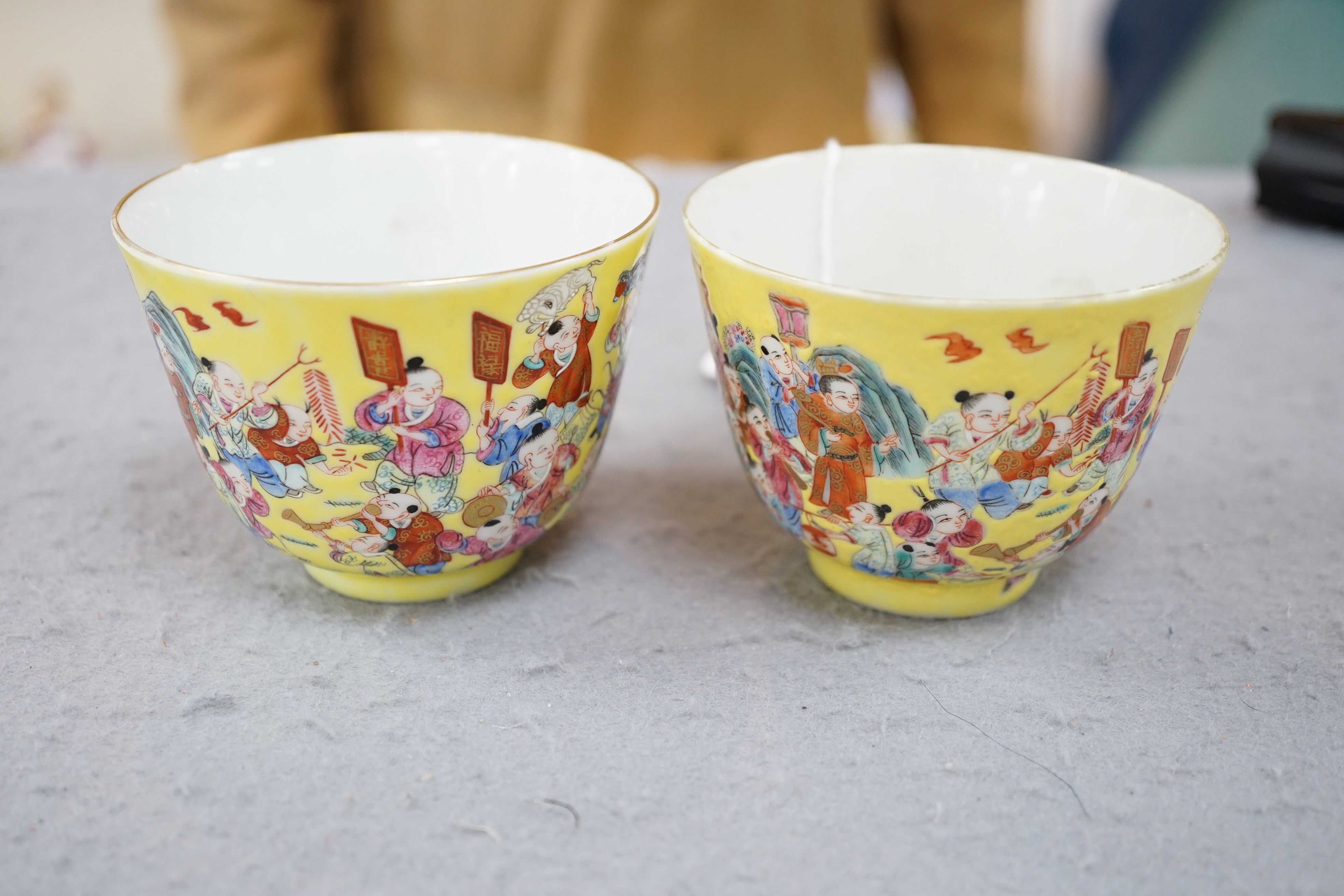 A pair of Chinese yellow ground 'Hundred Boys’ cups, 19th century, 6.5cm high 8.5cm diameter